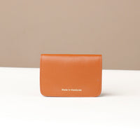 Brown leather wallet with 'Made in Honduras' text on a beige background