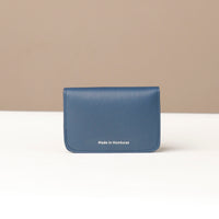 Blue wallet with 'Made in Honduras' text on a beige background