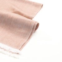 Folded beige fabric with white fringe on a white background