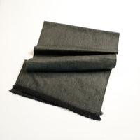 Dark gray fabric with frayed edges on a white background