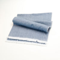 Rolled-up blue denim fabric on a white background