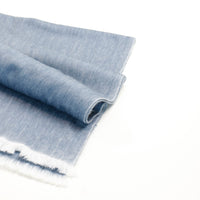 Rolled-up denim fabric on a white background