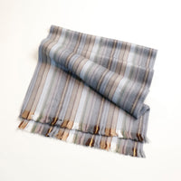 Striped scarf with shades of gray, beige, and brown on a white background