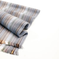 Roll of striped fabric with neutral colors on a white background
