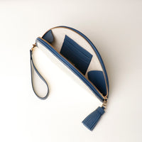 An open Clutch Agnes Junco Lavanda with blue leather strap and tassel, with three slots for credit cards, upper view