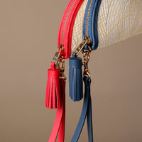 Close-up of two clutch agnes with tassels, one red and one blue, on a beige background.