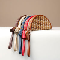 A collection of Agnes Clutches in various colors, made with natural fibers and full grain leather, displayed on a white surface.