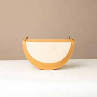 Semicircular handbag with beige exterior and white textured interior on a neutral background.