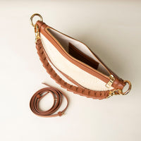 Brown leather handbag with detachable strap on white background