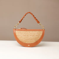 Brown handbag with straw texture and braided handle on a beige background