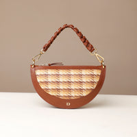 Brown handbag with braided handle on a beige background