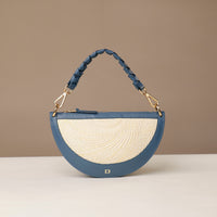 Blue and beige handbag with braided handle on a beige background