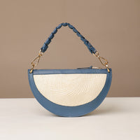 Blue and white handbag with textured strap on a beige background