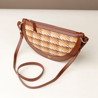 Brown crossbody bag with woven pattern on a white background