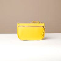 Yellow pouch with a zipper on a beige background