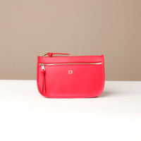 Red pouch with a gold zipper on a beige background