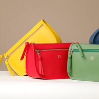 Three colorful handbags (yellow, red, green) with a visible brand logo on a neutral background.
