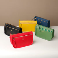 Five colorful handbags on a white surface with a beige background