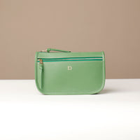 Green handbag with a visible brand logo on a beige background