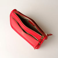 Red wallet with gold zipper on a white background