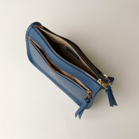 Blue wallet with gold zipper on a light gray background