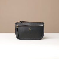 Black leather pouch with a visible brand logo on a beige background