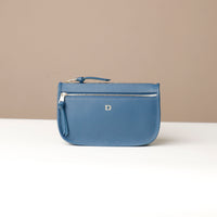 Blue handbag with a visible brand logo on a beige background