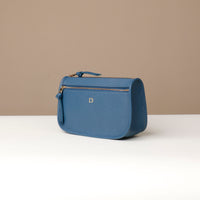 Blue handbag with gold zipper on a beige background