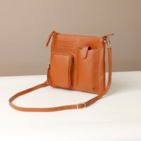 Brown leather crossbody bag on a white surface with a beige background