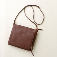 Brown leather shoulder bag on a light beige background