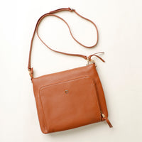 Brown leather crossbody bag on a light beige background