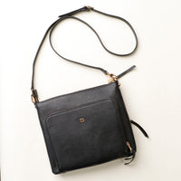Black leather crossbody bag with a strap on a white background