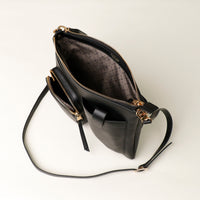Black handbag with gold accents on a light gray background