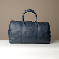Back view of Blue Premium leather duffle bag designed for travel with spacious interior, durable construction, and refined details