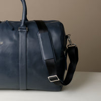 Close up view of Blue Premium leather duffle bag designed for travel with spacious interior, durable construction, and refined details