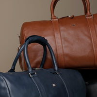 Close up view of 2 Premium leather duffle bag designed for travel with spacious interior, durable construction, and refined details