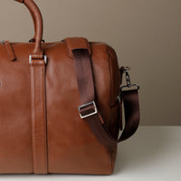 Close up view of Premium leather duffle bag designed for travel with spacious interior, durable construction, and refined details with strap.