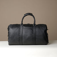 Back View of Black Premium leather duffle bag designed for travel with spacious interior, durable construction, and refined details