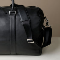 Close up View of Black Premium leather duffle bag designed for travel with spacious interior, durable construction, and refined details