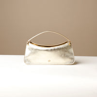 Front view of glossy gold Penelope Mini small leather handbag for versatile everyday use