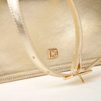 Close up view on the branding of gold Penelope Mini small leather handbag for versatile everyday use