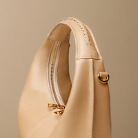 Close up view of brown Soft Rounded Bag crescent leather top-handle handbag