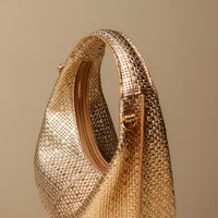 Close up view of gold Soft Rounded Bag crescent leather top-handle handbag