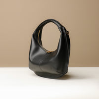 Side view of black Soft Rounded Bag crescent leather top-handle handbag