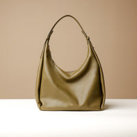 A Olive, hobo-style leather handbag with a slouchy silhouette and a minimalist design, displayed against a neutral background.