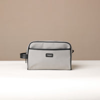 A gray toiletry bag with black trim, displaying its exterior
