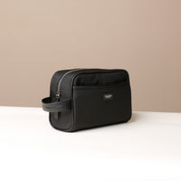 Angled View of a black Fabricio leather toiletry bag with roomy interior and organized compartments, perfect for travel or everyday storage of essentials