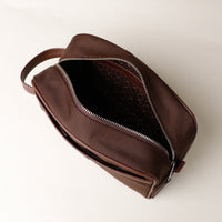 Open Brown Fabricio leather toiletry bag with roomy interior and organized compartments, perfect for travel or everyday storage of essentials