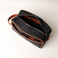 Open Black Fabricio leather toiletry bag with roomy interior and organized compartments, perfect for travel or everyday storage of essentials