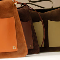 Close up of three Suede Penelope Sr. bag in Brown with fold-over magnetic closure 